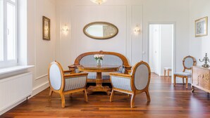 A dining room with a round table, four chairs, a chandelier, and a large mirror on the wall. - Imperial Apartments - Sopocki Style  (Sopot)