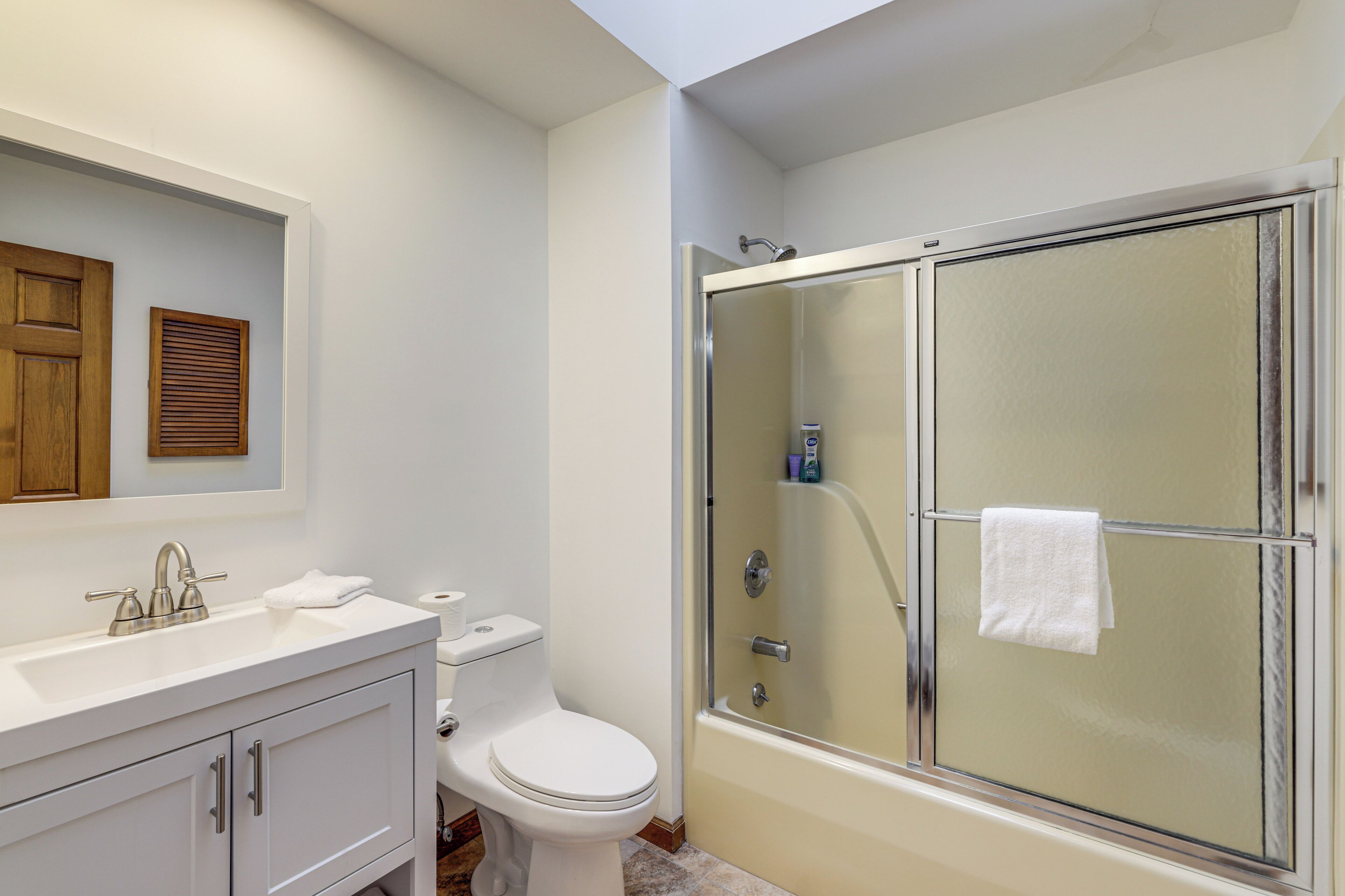 A bathroom with a toilet, sink, and a glass-enclosed shower.