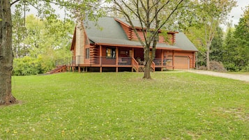 Surrounded by lush greenery, this cabin features a charming front porch and easy access to the main entrance.