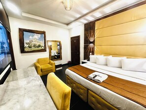 A hotel room with a bed, a desk, a chair, a large mirror, and a picture on the wall. - Presken White House Micheal Olawale (Lekki)