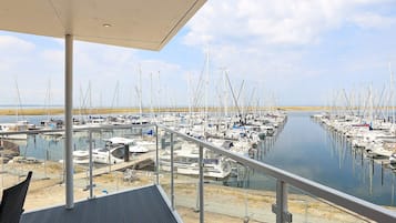 Eine Marina mit vertäuten Booten in ruhigem Wasser, einem überdachten Deck und wolkenlosem Himmel.