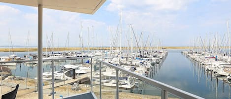 Una marina con barcos amarrados en aguas tranquilas, una zona de cubierta techada y cielo despejado.