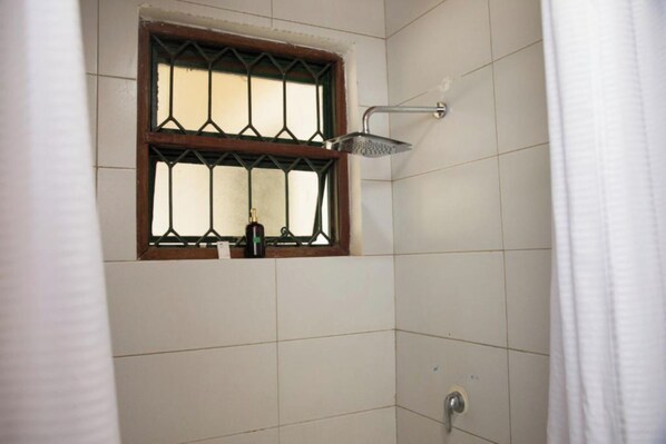 Ein Duschbereich mit Fenster und Duschkopf.