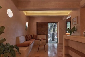 Um interior moderno com um sofá, uma mesinha e um balcão de recepção.