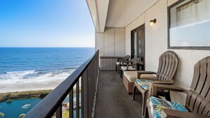 A balcony with a view of the ocean, wicker furniture, and a small table. - T1513 at the Myrtle Beach Resort (Myrtle Beach)