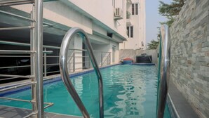 A swimming pool with metal railings and a clear blue water surface. - Presken Luxury Apartment (Lagos)
