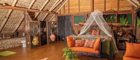 A cozy, rustic bedroom with a wooden ceiling, a bed with a canopy, and a round table with a plant.