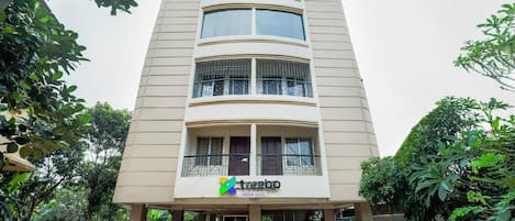 A multi-story building with a modern design, featuring balconies and large windows.