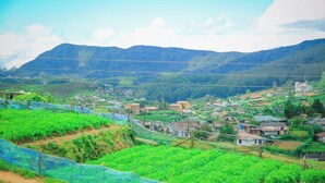 A rural landscape with terraced fields, a small village, and mountains in the background. - Olivia Hotel Nuwaraeliya (Nuwara Eliya)