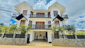A two-story house with a balcony, a stone entrance, and a clear sky. - Olivia Hotel Nuwaraeliya (Nuwara Eliya)
