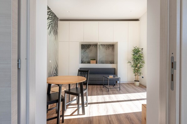 Un intérieur moderne comprenant un coin repas, un canapé et une grande fenêtre.
