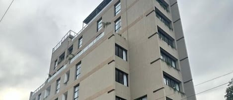 A tall, modern building with multiple floors, large windows, and a glass facade.