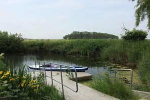 A calm river with a dock and a small boat.