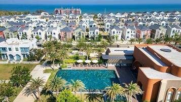 Alberca al aire libre, sombrillas en la alberca y camastros