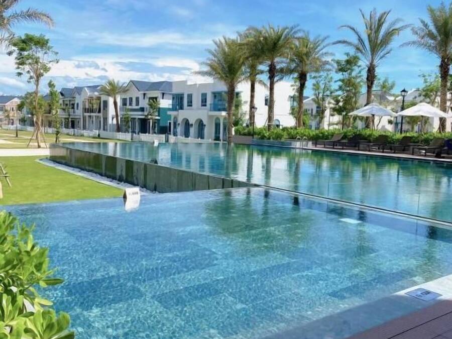 Una piscina al aire libre, sombrillas, tumbonas