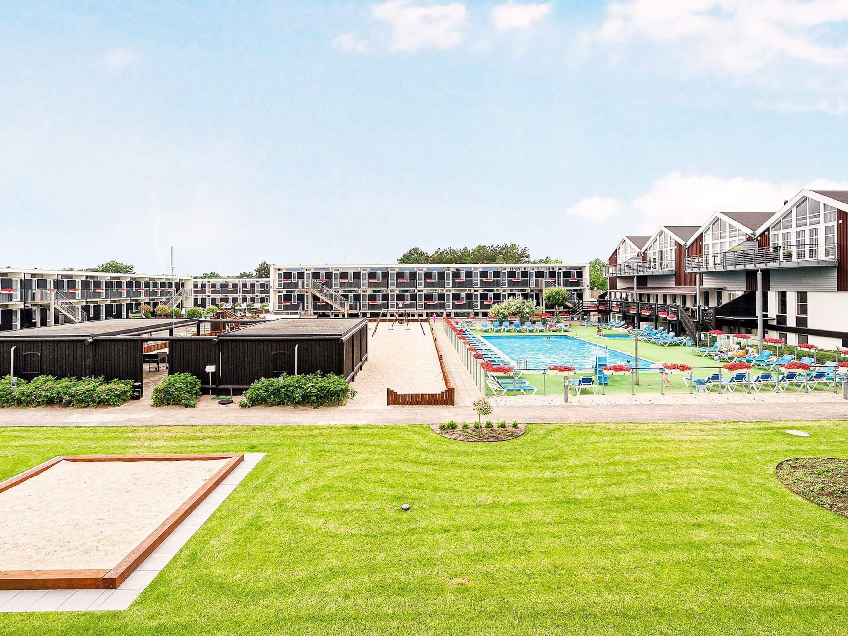 A hotel with multiple floors, a swimming pool, and outdoor seating areas.