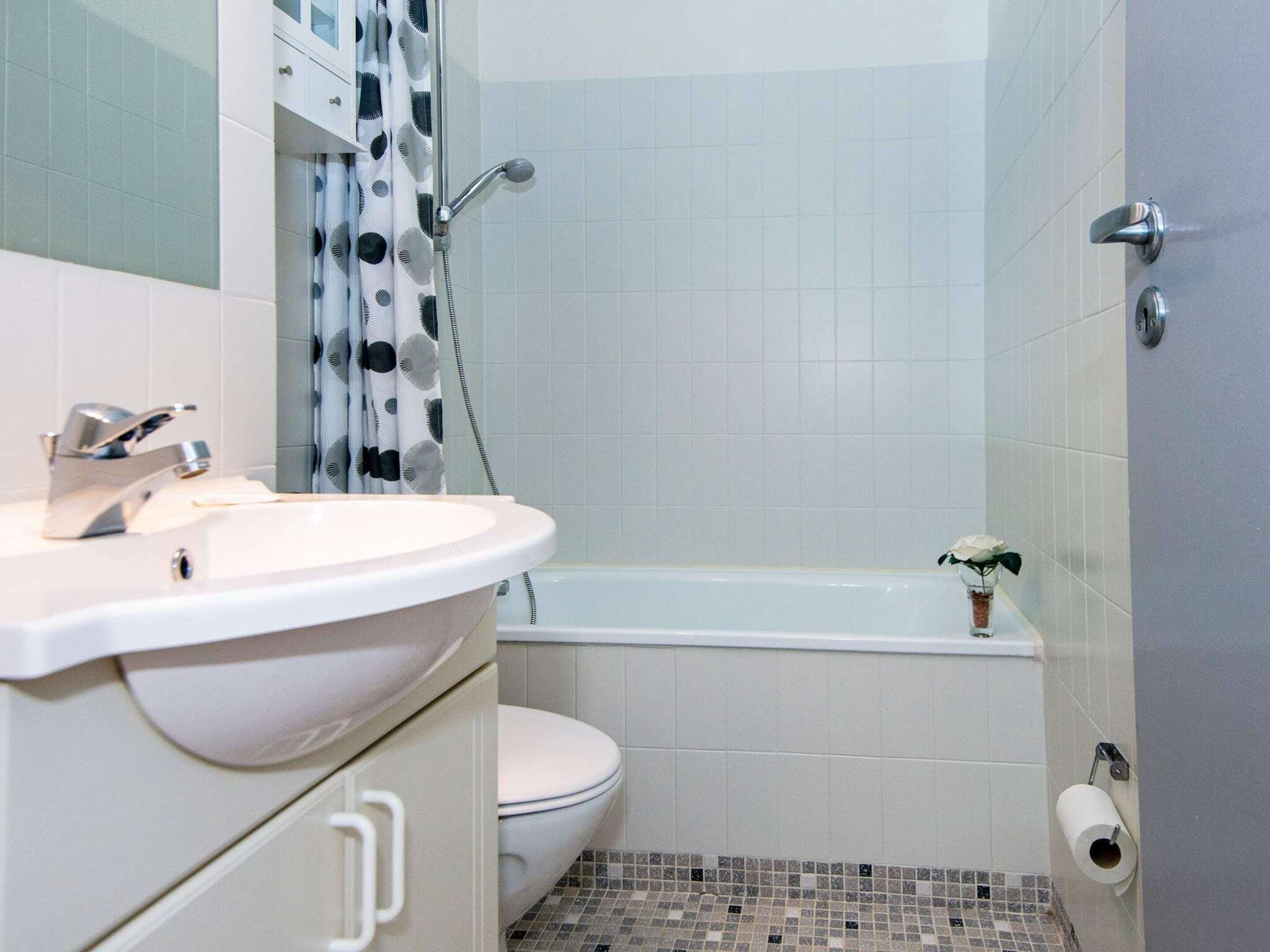 Un baño con lavamanos, inodoro y bañera.