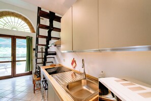 Estudio superior, patio, planta baja | Cocina privada | Refrigerador con congelador, microondas, horno y parrilla de estufa 