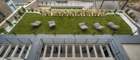 Un jardin sur le toit, aménagé avec des espaces pour s’asseoir et une piscine.