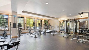 A spacious gym with various exercise equipment, large windows, and a clean, modern design. - Beaver Creek Landing A408 (Beaver Creek)