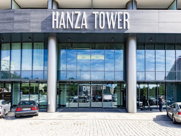 En moderne bygning med skiltet "HANZA TOWER" over indgangen.