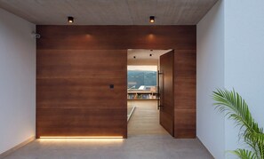 Experience the serene atmosphere of this stylish space, featuring a large wooden panel wall, light-colored tile flooring, and a potted plant.