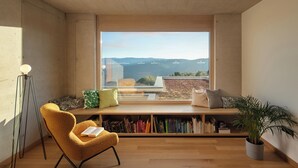 A reading nook with a large window, a chair, a bookshelf, and a potted plant. - Villa Immortella, GreenTree - 6 persons, 3 bedroom luxury villa with seaview (Rabac)