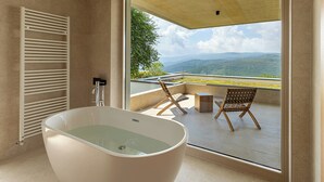 A modern bathroom with a freestanding bathtub, a shower, and a large window offering a view of a mountainous landscape. - Villa Immortella, GreenTree - 6 persons, 3 bedroom luxury villa with seaview (Rabac)