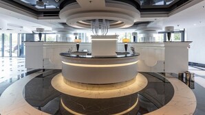 A modern reception area with a central circular counter, marble flooring, and contemporary lighting fixtures.
