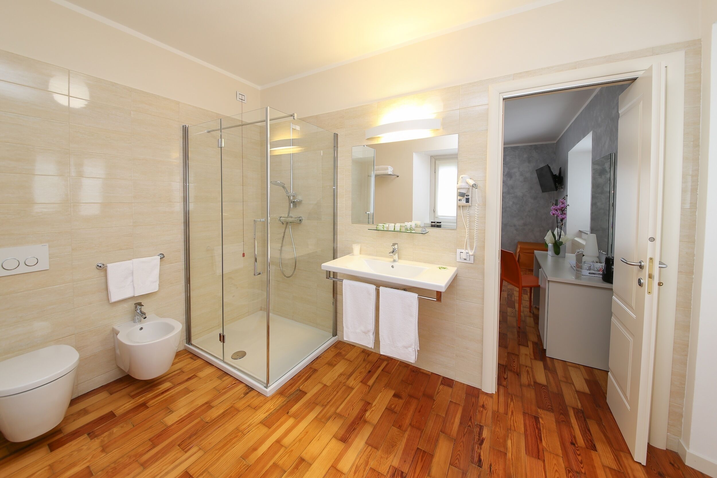 Un baño moderno con ducha de vidrio, lavamanos e inodoro.
