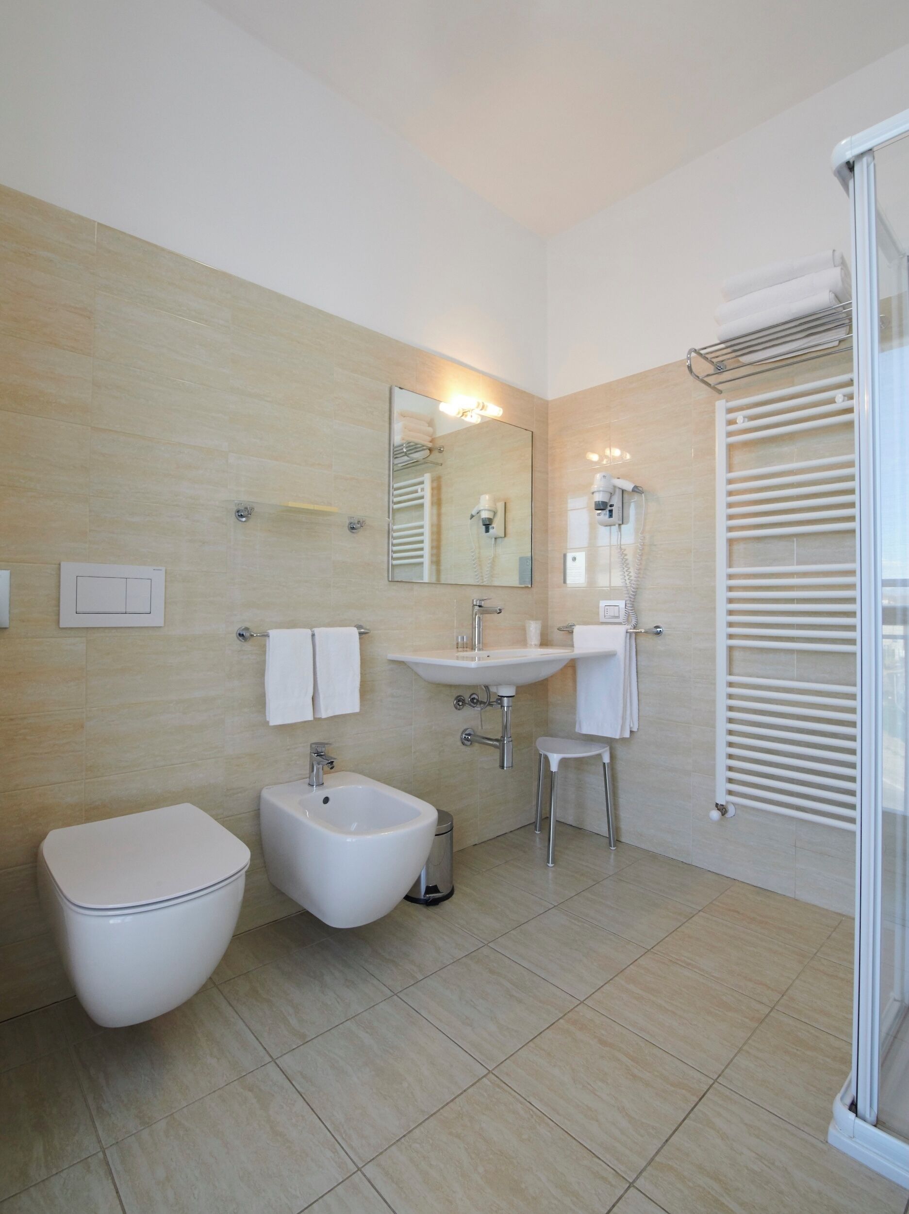 Ein modernes Badezimmer mit einer Bidet, einem Waschbecken und einem Spiegel.