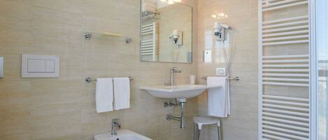 A modern bathroom with a bidet, a sink, and a mirror.