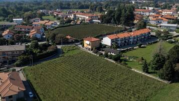 Vue aérienne d’un quartier résidentiel avec des maisons, un vignoble et un grand bâtiment doté d’un toit rouge.