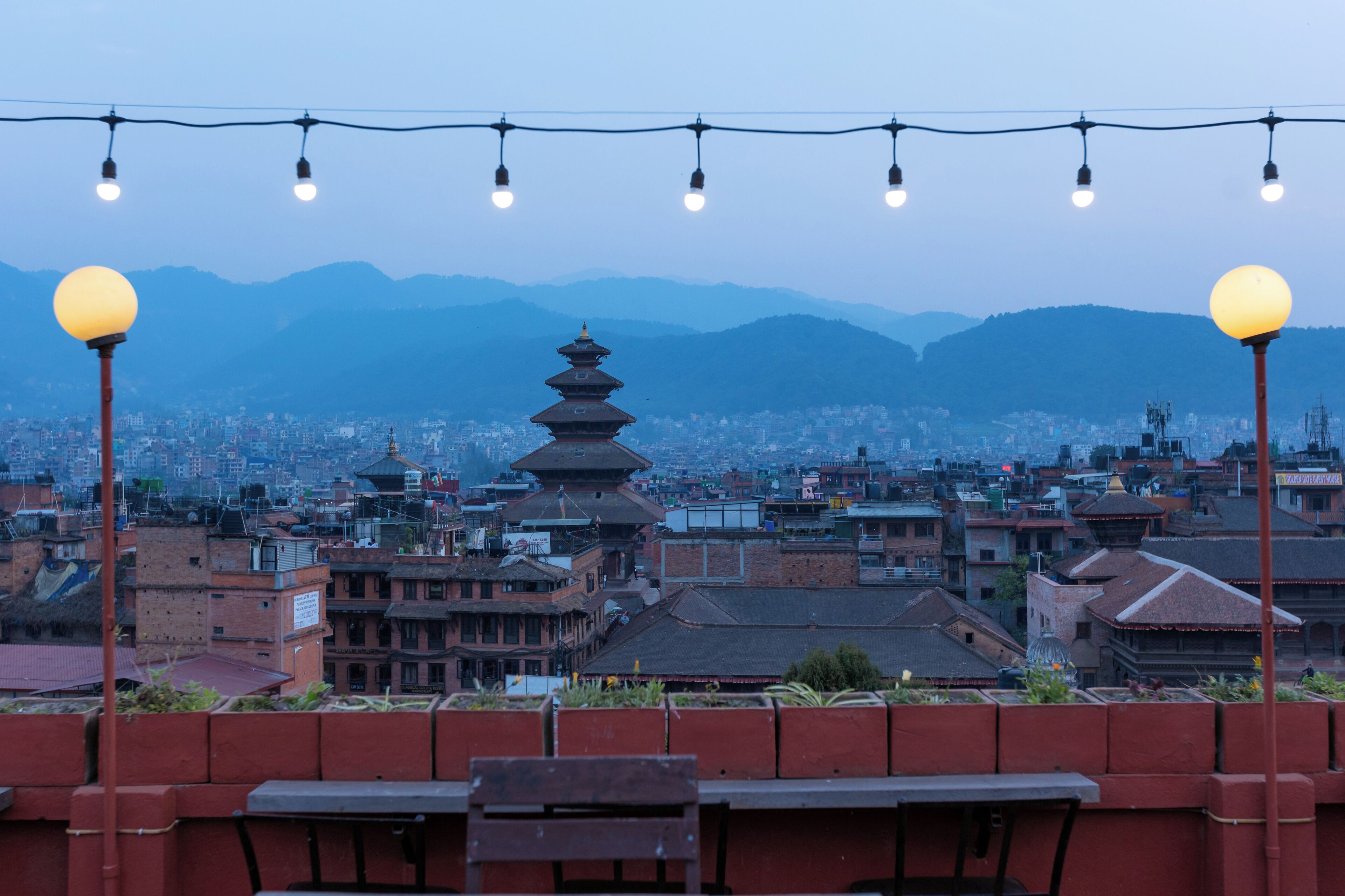 Une vue sur la ville, avec un paysage urbain caractérisé par une architecture traditionnelle, notamment une pagode, et une perspective sur la ville située en contrebas.