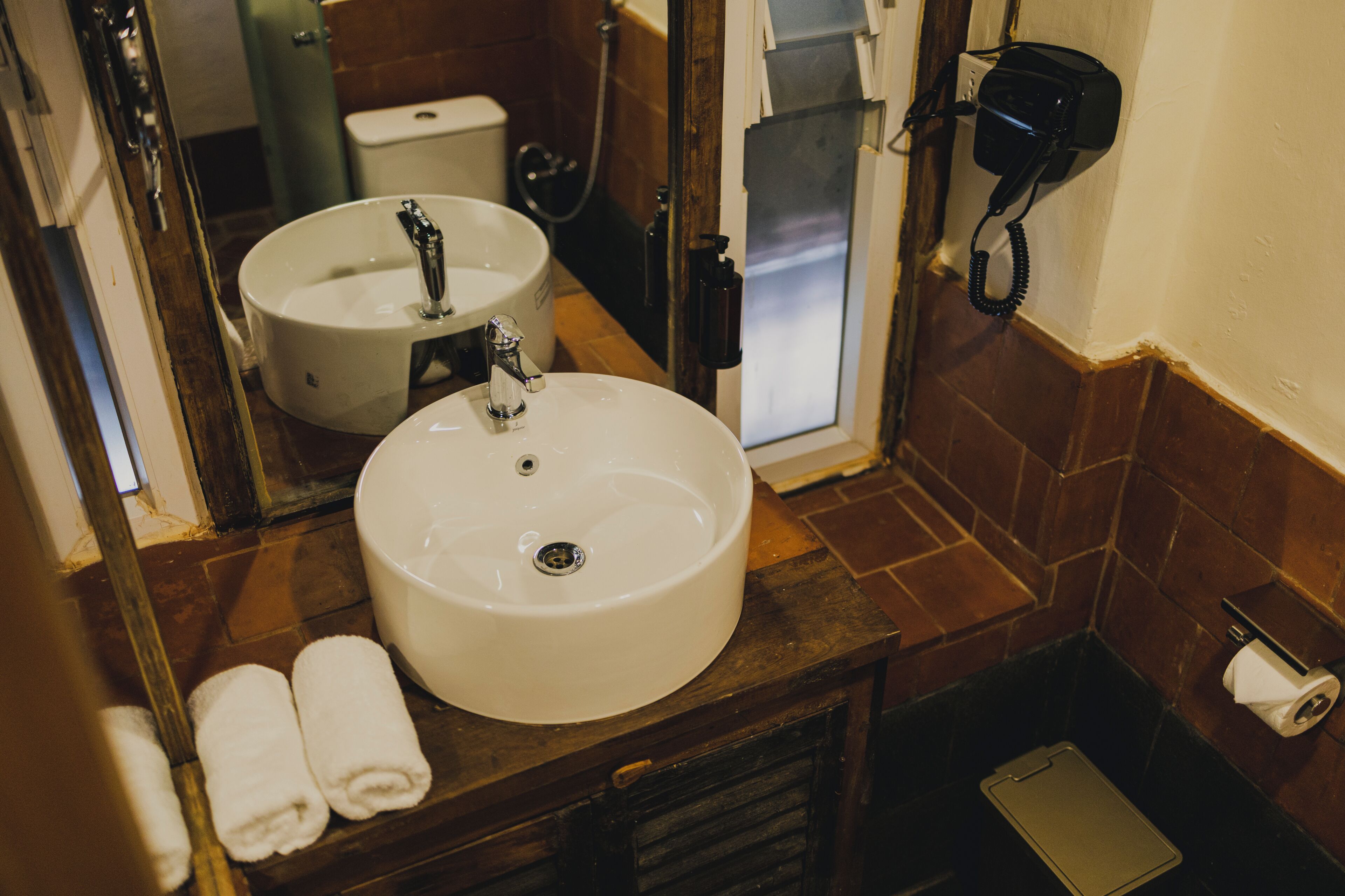 Een badkamer met twee wastafels, een spiegel, een handdoekhouder, een toilet en een douche.