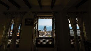 Habitación con vista a una pagoda a través de una ventana con diseño de celosía.