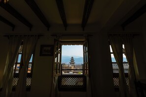 Habitación con vista a una pagoda a través de una ventana con diseño de celosía.