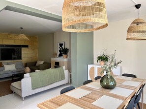 Relax and socialize in this stylish living space, featuring a dining area, comfortable seating, and an entertainment unit.