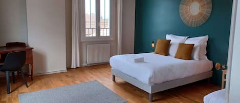 A bedroom with a bed, a desk, and a chair.