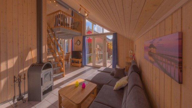 Ein geräumiges Zimmer mit Holzboden, einer Couch, einem Couchtisch und einem Bild an der Wand.