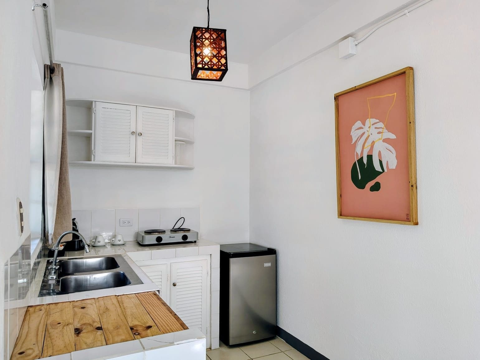 A compact kitchen with a sink, stove, and a small refrigerator.