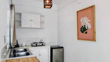A compact kitchen with a sink, stove, and a small refrigerator.