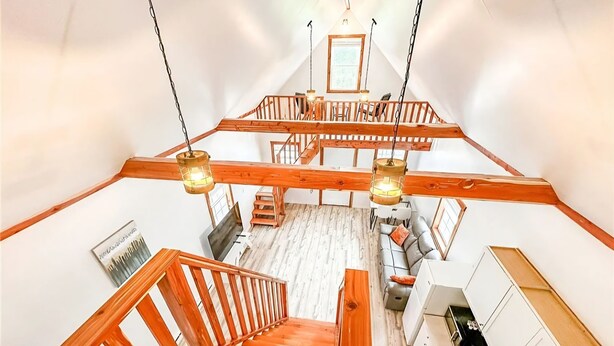 A spacious loft with a wooden staircase, a dining area, and a kitchen. - Charming cottage Pulaski VIP Rentals 1.8 miles away from famous salmon river (Pulaski)
