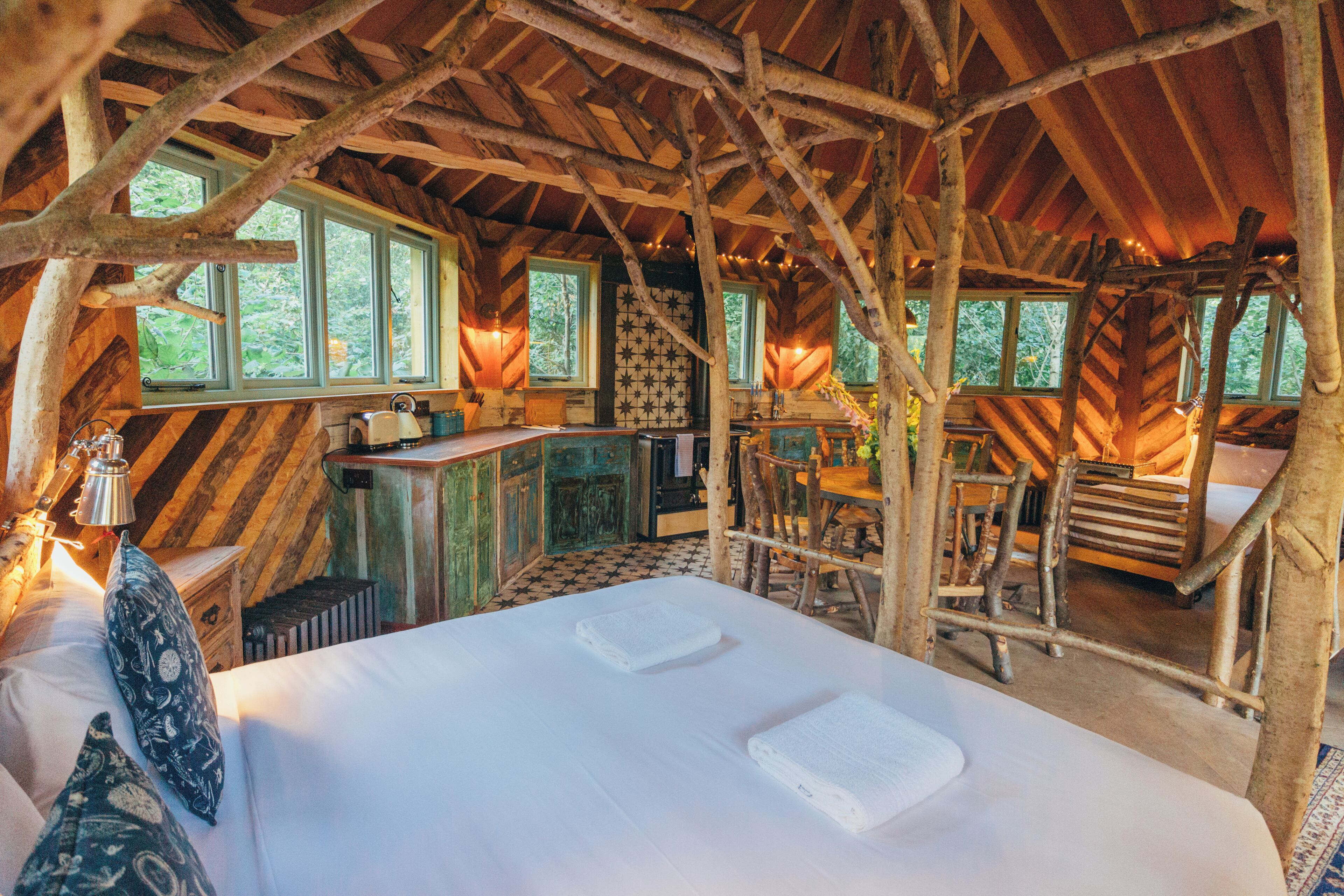 Een rustieke blokhut met een slaapkamer op een entresol, een eethoek en een keuken.