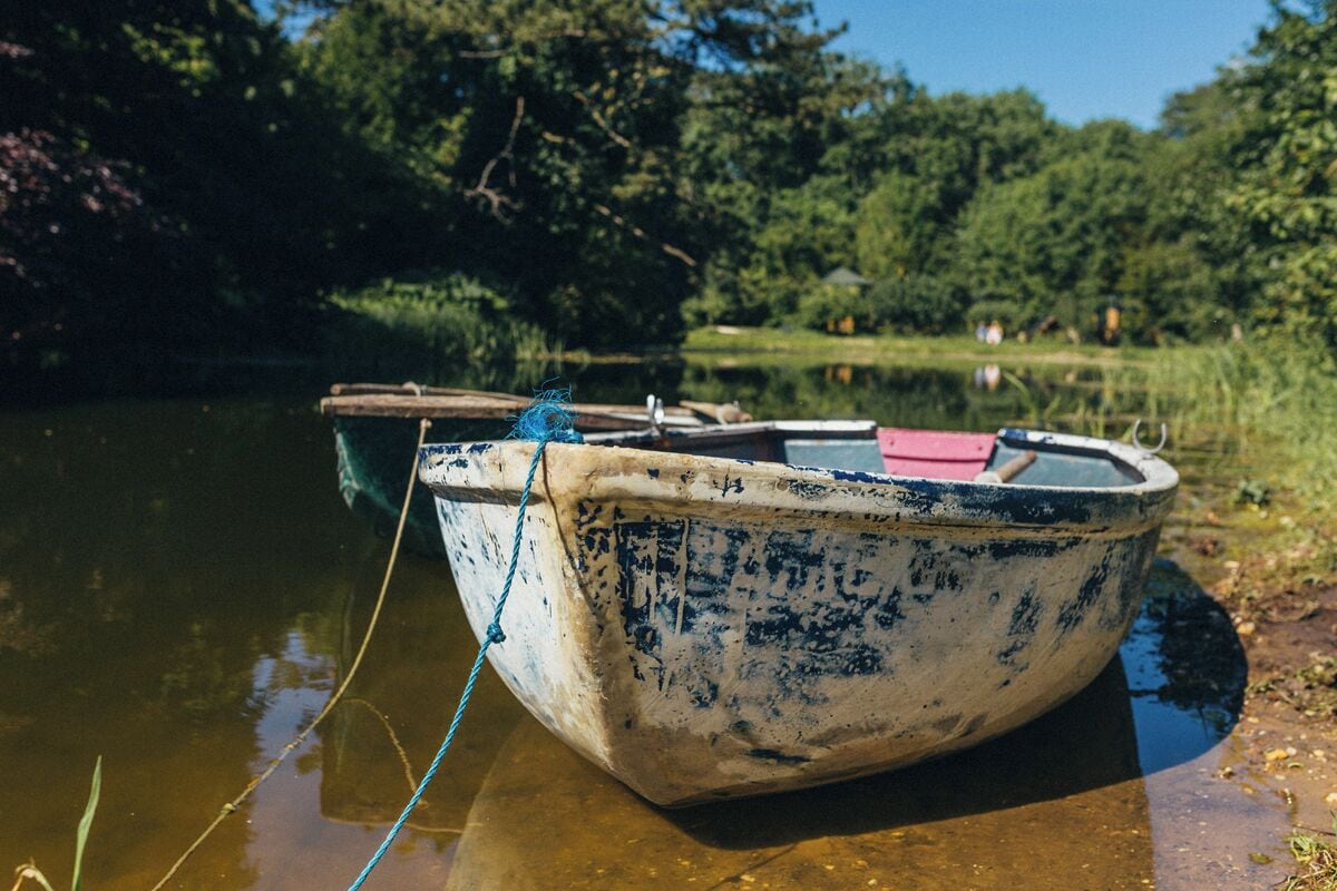 Un petit bateau rustique, amarré à un quai par une corde.