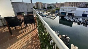 Un balcón con vista a un puerto deportivo y edificios.