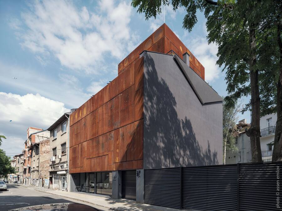 Un edificio moderno con un diseño arquitectónico único, que combina materiales de metal y hormigón.