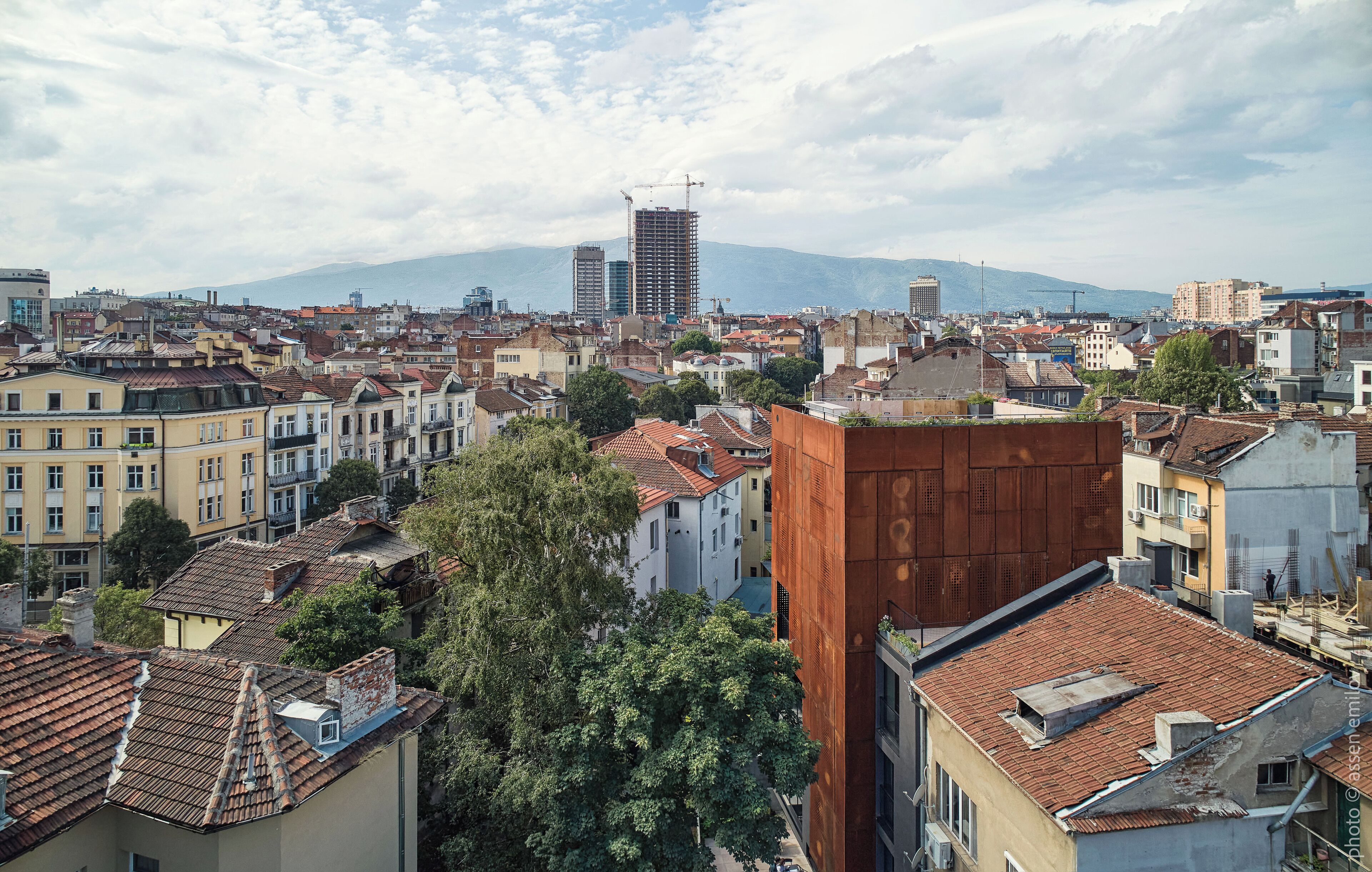 Un paisaje urbano con una mezcla de edificios históricos y modernos, incluyendo una construcción destacada con una grúa.