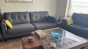 A living room with a grey sofa, a wooden coffee table, and a patterned box. - Lovely 2-bed Apartment -sleeps 5 & Parking (Dublin)