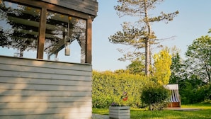 A wooden building with a balcony and a hanging light fixture. - Ferienwohnung in St. Peter-ording (St. Peter-Ording)